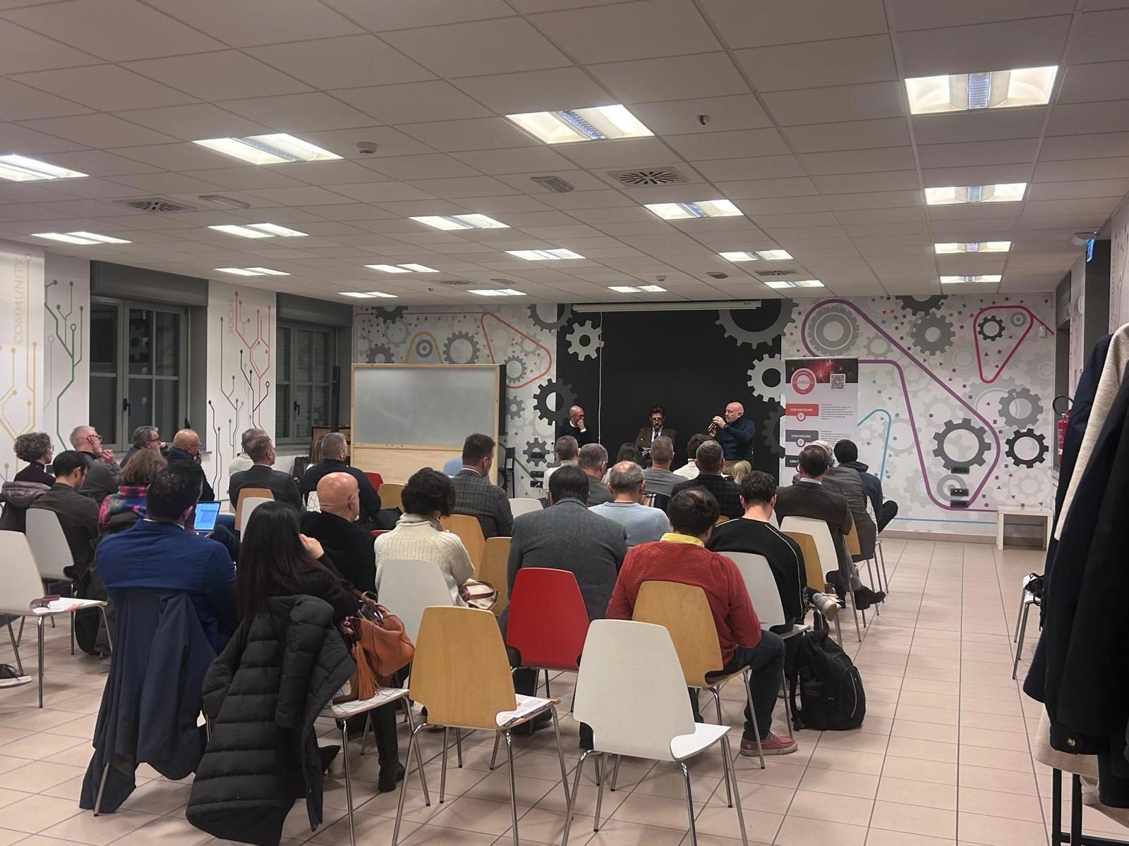 Sala dell'evento presso Open Incet, Torino, con il pubblico in ascolto durante l'Evento Zero di First Personal Coin.